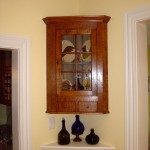 Hanging curly maple corner cabinet with glass door